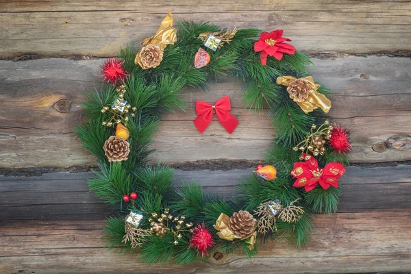 Outdoor Christmas conifer wreath at old log cabin wall background — Stock Photo, Image