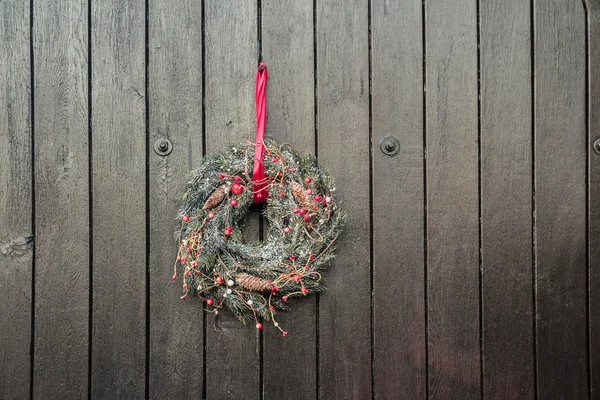 Рождественские праздники Адвент венок висит снаружи на фоне коричневых деревянных ворот Стоковое Фото