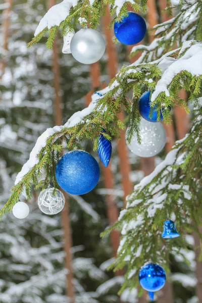 Рождественский праздник сверкающие безделушки белые и лазурные украшения на открытом воздухе на снежных еловых ветвях Стоковое Фото