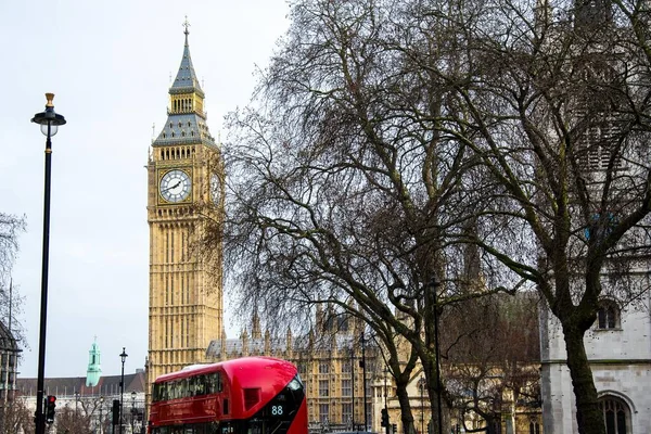 A double decker bus driving down Big Ben street