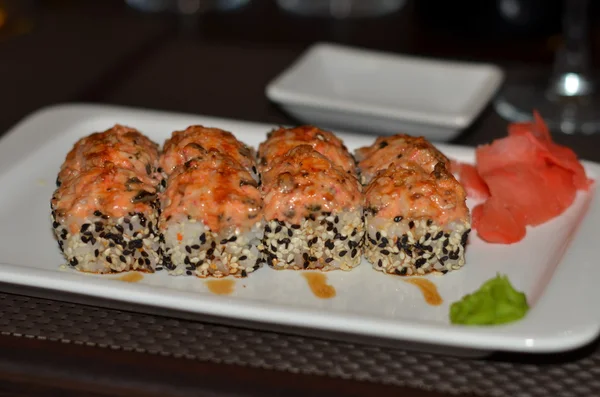 Beyaz ve siyah susam ile beyaz tabakta sıcak Japon rulo