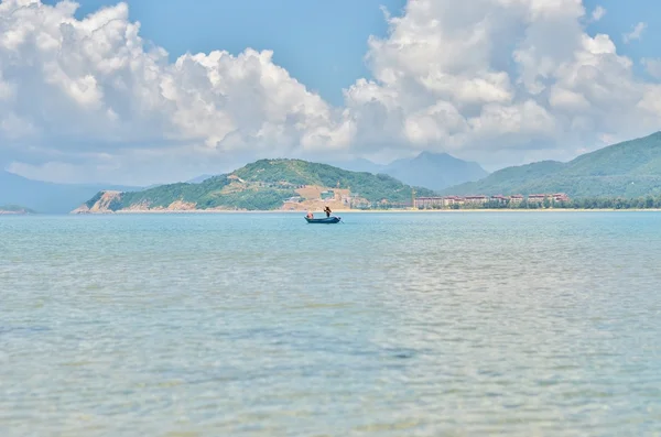 Berg überwuchert und einsames Boot auf See — Stockfoto