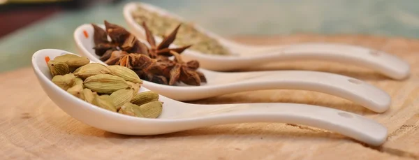 Yeşil kakule, yıldız anason ve bir kesim ağaç beyaz Seramik kaşık rezene tohum