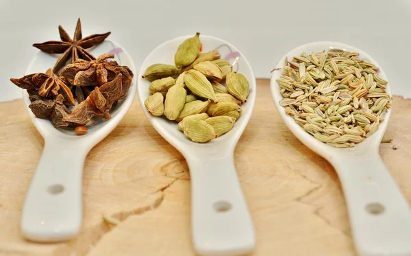 Yeşil kakule, yıldız anason ve bir kesim ağaç beyaz Seramik kaşık rezene tohum