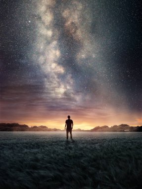 Samanyolu galaksisi gökyüzünü yukarıdan doldururken bir adam gece gökyüzünü keşfediyor. Fotoğraf bileşimi