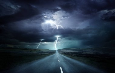 Olağanüstü hava koşulları. Yıldırımlı güçlü bir fırtınaya doğru giden bir yolu olan boş bir arazi. Fotoğraf bileşimi.