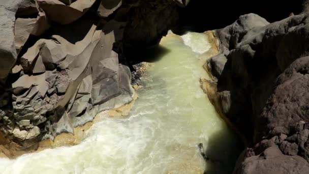 Air mineral yang mengalir dari Danau Segara Anak danau di kawah Rinjani gunung berapi. Sungai dengan air berwarna susu. Air Sulphurous dari kawah gunung berapi. Air terjun berwarna abu-abu kehijauan — Stok Video