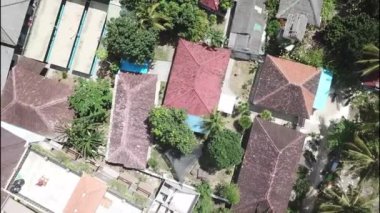 Tropik bir ada olan Nusa Penida, Endonezya 'da palmiyeler arasında saklı kırmızı çatı bungalovları