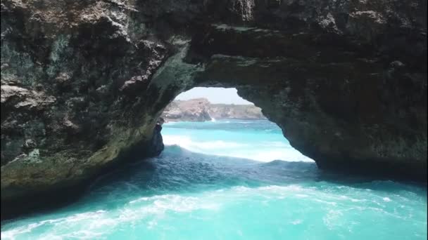 Skalne wybrzeże i kamienny łuk nad lazurowym morzem w Broken Beach, Nusa Penida, Bali, Indonezja. Widok z powietrza 4K — Wideo stockowe