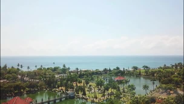 Bali Ujung famoso palazzo dell'acqua. un parco con canali e alberi verdi e palme circondato dal mare e dalla foresta. un luogo turistico popolare da visitare in Indonesia. Dron shot. vista aerea — Video Stock