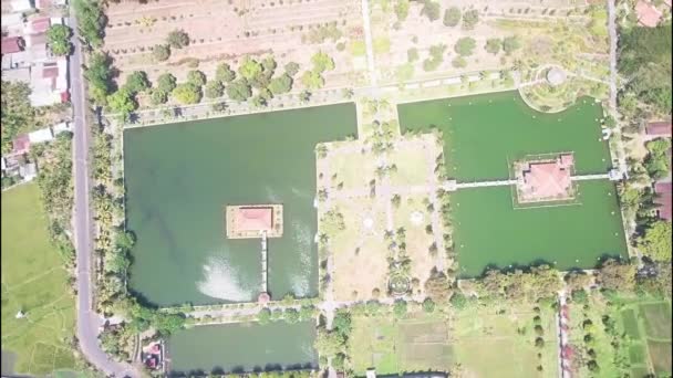 Bali Ujung famoso Palacio del Agua. un parque con canales y árboles verdes y palmeras rodeadas de mar y bosque. un lugar turístico popular para visitar en Indonesia. Disparo dron. vista aérea — Vídeos de Stock