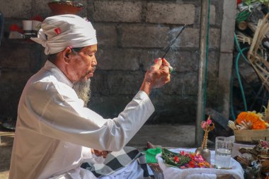 Dua sırasında bir Balili pedanda 'nın yanına yaklaş. Bir Hindu rahibin tören yaparken yan görüntüsü. Endonezya, Bali 'deki Pemuteran tapınağında adak adamış bir Hindu rahip.