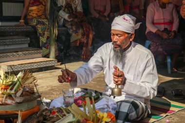 Bir düğün töreninde dua eden Hindu rahibi. Pedanda adakların önünde oturur ve nikah kıyar.