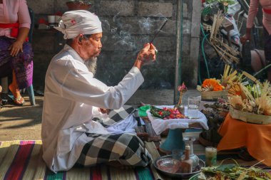Beyaz üniformalı Hindu rahip, dini bir tören yapıyordu. Melodik bir çan ve güzel ve huzurlu bir ilahiyle..
