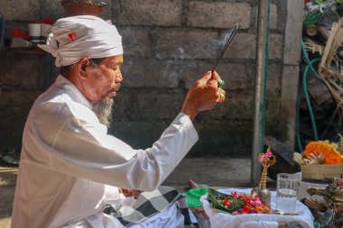 Ubud, Denpasar, Bali, Endonezya 'da bir Ngaben ayini düzenleyen Balili başrahibin yakın plan fotoğrafı..