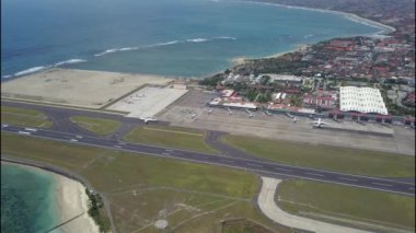 Endonezya, Bali 'deki Denpasar Havaalanı' nda ticari uçak taksisi. Kalkışa hazırlanan büyük bir jetin insansız hava aracı görüntüsü. Jet uçağı piste dönüyor. Yolcu jeti kalkışa hazırlanıyor.