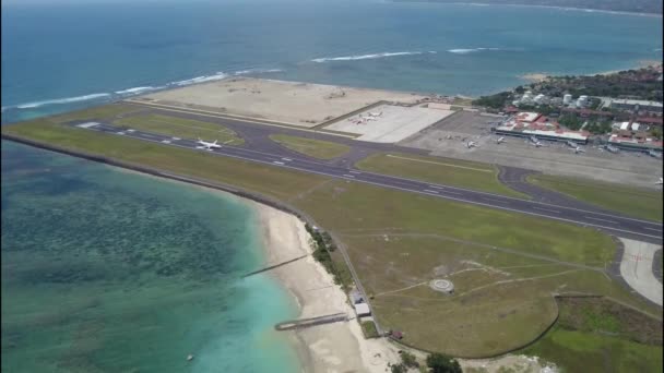 Ticari uçak Denpasar Uluslararası Havaalanı, Endonezya 'dan kalkıyor. Bali Havaalanı 'ndan kalkan uçak. Yolcu uçağı şehirden ayrılıyor. Uçak Ngurah Rai Havaalanından kalkıyor. — Stok video