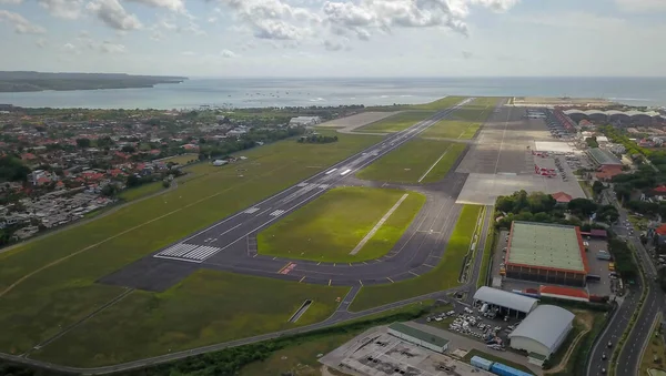 Widok wyspy Bali po starcie samolotu z lotniska Ngurah Rai International. Pas startowy sięgający do oceanu. Widok z lotu ptaka na międzynarodowe lotnisko w Denpasar — Zdjęcie stockowe