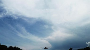 Blue Sky 'a karşı uçan uçak. Kalkıyor. Uçak inişinin silueti. 4K video. Ulaşım konsepti. Günbatımında ya da gün doğumunda havaalanına inmeye hazırlanan uçak tepemizde uçuyor.