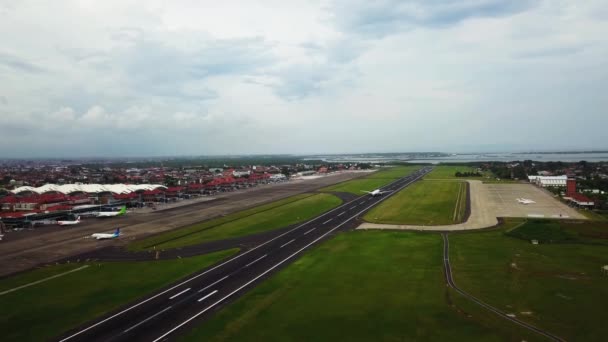 Drone view of planes taking off at a small airport. A big aircraft takes off from an airport in Bali. Departures of aircraft of the National Indonesian Society. 4k video footage — Vídeo de stock