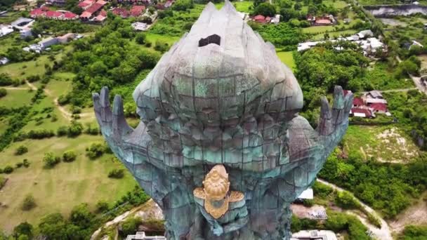 Tájkép a legmagasabb Garuda Wisnu Kencana GWK szoborról mint Bali mérföldkő kék égbolttal a hátterében. Balinéz hagyományos szimbóluma hindu vallás. Népszerű úti cél Indonéziában — Stock videók
