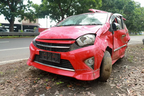 The red car was hit with a broken headlamp and a wrinkled bonnet — Stock Photo, Image