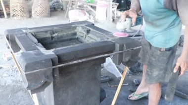 Asyalı adam fabrikadaki taş levhaları ölçer. Endüstriyel fabrika arka planında kesilmiş taş levhalar. Endonezya 'da, Bali' de imalat işçisi.