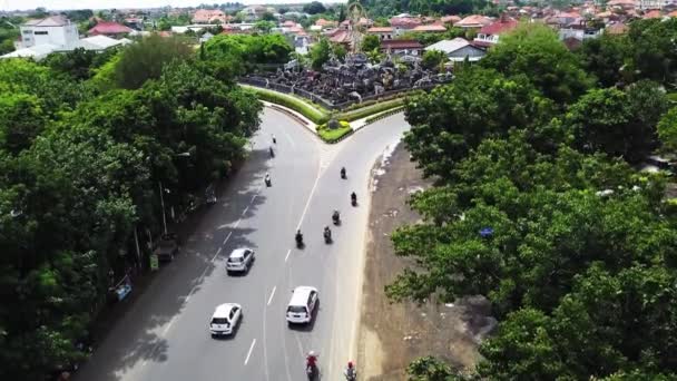 Bali Lindo tiro aéreo rotunda com um drone. Tráfego na rotunda da auto-estrada Jalan Bypass. Imagens aéreas de Patung Titi Banda monumento em Denpasar, Bali, Indonésia — Vídeo de Stock