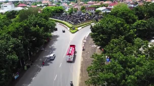 Bali Piękne rondo z lotu ptaka z dronem. Ruch na rondzie na drodze ekspresowej obwodnicy Jalan. Nagranie z dronów lotniczych pomnika Patung Titi Banda w Denpasar, Bali, Indonezja — Wideo stockowe