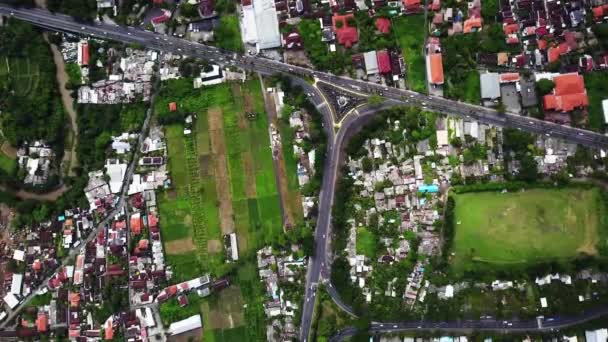 Voo com vista para a cidade de Bali. Tráfego ocupado em torno da rotunda com o monumento Patung Titi Banda. Lindo tiro aéreo com um drone — Vídeo de Stock