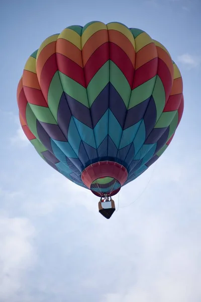 Balão de ar quente multicolorido no céu azul nublado. Balão de ar quente bonito contra um céu azul profundo e nuvens — Fotografia de Stock