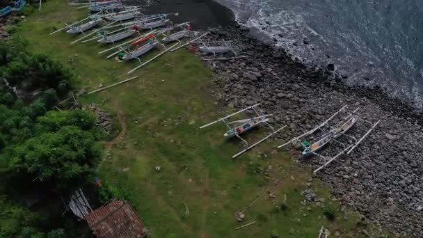 Vue aérienne, du haut vers le bas, tir de drone panoramique sur une plage pleine de bateaux de pêche. — Video