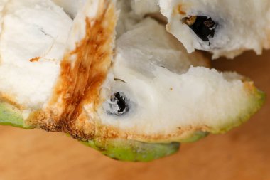 Açılmış ve el değmemiş elma şekeri ya da ahşap bir masa ve dış peeling üzerindeki ANNONA SQUAMOSA 'nın yukarıdan aşağı manzarası. Kapat.