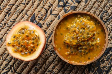 Ahşap kasedeki taze tutku meyvesi ahşap masa üzerinde düz zemin veya arka plan veya duvar kağıdı için fotokopi alanı ile yatıyordu. Olgun tutku meyvesi çok tatlı ve ekşi. Tropik meyve.