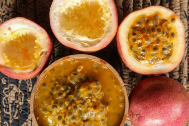 Ahşap kasedeki taze tutku meyvesi ahşap masa üzerinde düz zemin veya arka plan veya duvar kağıdı için fotokopi alanı ile yatıyordu. Olgun tutku meyvesi çok tatlı ve ekşi. Tropik meyve.