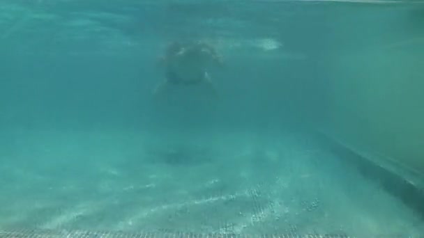 A víz átfolyik a medence szélén az alsó medencébe. A túlcsorduló medence széle. Vízlépcső. Egy férfi úszik egy vízmedencében, ami végigfolyik a szélén. — Stock videók