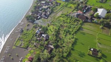 Pantai Amed plajından gelen uçuş. Bali, Endonezya plajı havadan görünüyor. Siyah volkanik kum kıyı şeridi üzerinde uçan manzaralı bir hava.