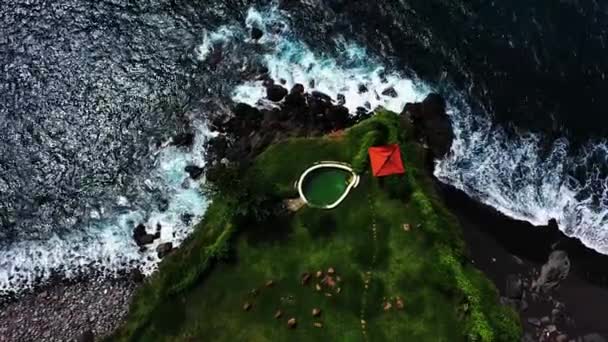 Uçurumun kenarındaki yüzme havuzunun en üst manzarası. Okyanus manzaralı. Uluwatu, Bali, Endonezya. Kayalık uçurum ve kıyı şeridinde harika bir yerin havadan görüntüsü. Tatil için hedef — Stok video
