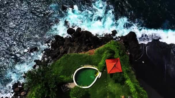 Vista superior de la piscina en el borde del acantilado con la vista del océano. Uluwatu, Bali, Indonesia. Vista aérea de un lugar increíble en el acantilado de roca y la costa. Destino de vacaciones — Vídeos de Stock