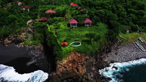 Vista aérea drone para moradia com piscina na costa rochosa em Bali. Vista aérea de um incrível bangalôs no penhasco da rocha. Vista superior de casas e piscina no penhasco. Destino para férias — Vídeo de Stock