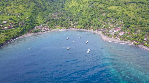 Aerial drone view from the sea to the Jemeluk Bay. Amed is fast becoming a popular tourist destination in Bali, Indonesia. It is a home to excellent snorkeling, scuba diving, freediving and yoga