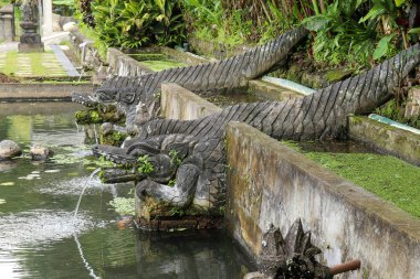 Endonezya 'nın Bali adasındaki Karangasem bölgesindeki Tirta Gangga' da yapay bir havzanın yanında fıskiye bulunan taş bir hayvan heykeli.