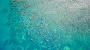 Aerial view of tropical island beach holiday. Blue reef ocean. Aerial view of calm sea water. Top view of a clean ocean water near a coast.