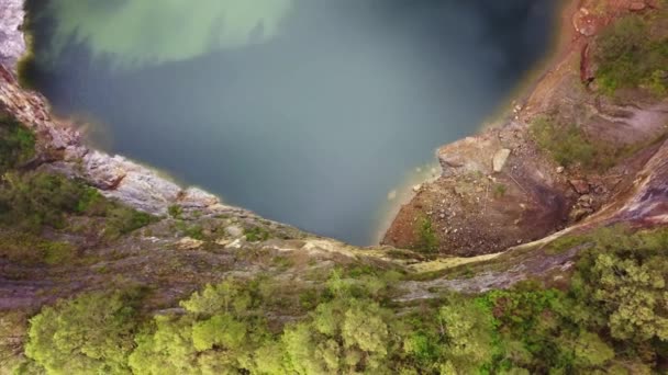 Atas ke bawah pandangan pesawat tak berawak ke Danau Abutu, Danau Tua. Danau Tiwi Ata Mbupu di Kelimutu. Terbang di atas tepi kawah dengan danau hitam. Pemandangan udara di pagi hari, Indonesia — Stok Video