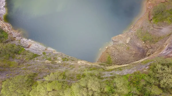 Top down drone view to Danau Abutu, Lake of the Older. The lake Tiwi Ata Mbupu on Kelimutu. Flight over the edge of a crater with a black lake. Aerial view early morning, Indonesia — Stock Photo, Image