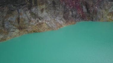 İnsansız hava aracı volkanik Kootainuamuri Gölü 'nün turkuaz yüzeyinde ilerliyor. Genç ölü insanların ruhlarının gölü. Genç adam ve bakirelerin volkanik gölü Tiwu Nuamuri Koofai