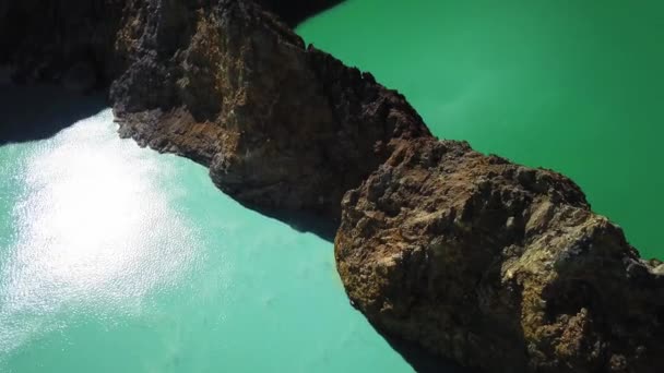 火山の上の真ん中に岩壁を持つ2つの側面湖の空中旅行ビュー インドネシアの早朝 霧に覆われたクレムツ3色の火山噴火口 — ストック動画