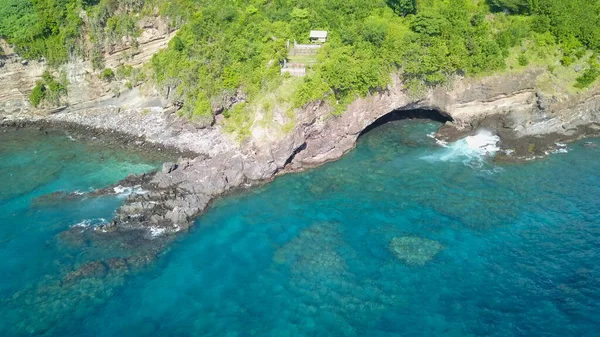 岩石海岸上的洞穴。巴厘岛的热带天堂空中无人机俯瞰巴厘岛海岸的一个洞穴 — 图库照片