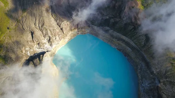 インドネシアのフローレスにあるクレフルート火山の火口湖の無人機のトップダウンショット。湖は水の中の鉱物のおかげで非常に強いターコイズ色をしています。自然現象 — ストック写真
