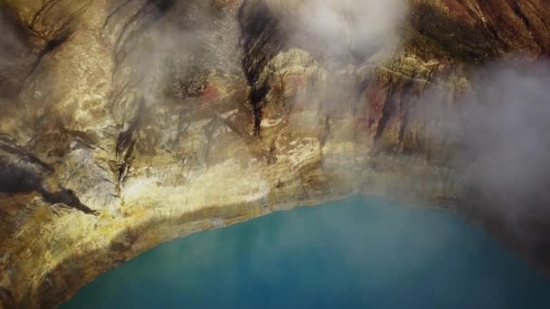 A drone capture of an early morning over the Kelimutu Lakes on Flores, Indonesia. The volcanic lakes are located in volcanic craters. One of the lakes is covered with fog. Golden hour. Calmness — Stock Video